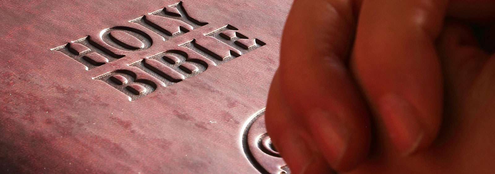 Hands Praying On Bible